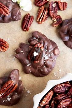 chocolate pecan cookies with nuts and sea salt in the middle on a piece of parchment paper