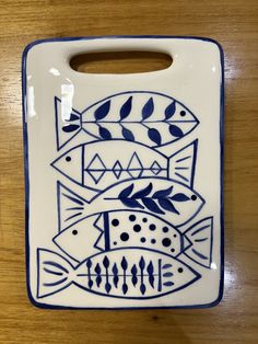 a blue and white ceramic dish with fish on it