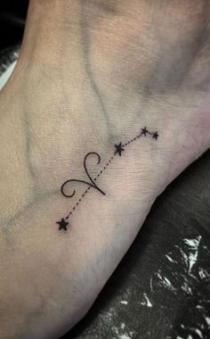 a small tattoo on the foot of a woman's foot, with stars in the middle