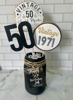 a 50th birthday cake topper in a jar