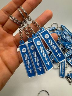 a hand holding a bunch of blue key chains