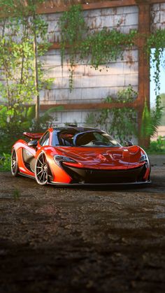 an orange and black sports car parked in front of a building