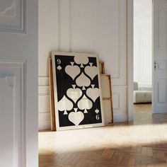 a black and white art piece sitting on top of a hard wood floor next to an open door