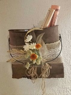 a brown purse with flowers and other items hanging on the wall next to a tube of toothpaste