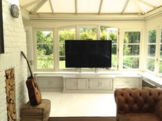 a living room filled with furniture and a flat screen tv mounted on a wall above a fireplace