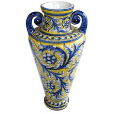 a blue and yellow vase sitting on top of a table