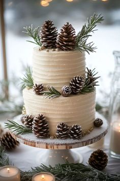 a three tiered cake with pine cones on top