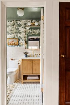 an open door leading to a bathroom with floral wallpaper