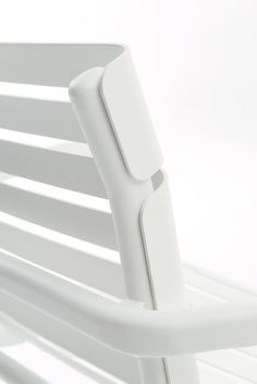 a white plastic chair is shown against a white background with the seat up and arm down