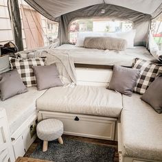 the inside of a camper with couches and pillows on it's side