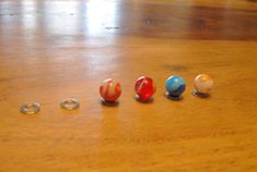 five glass knobs are lined up on a wooden table