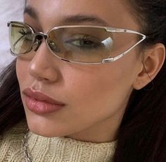 a close up of a woman wearing glasses and a turtle neck sweater with chain around her neck