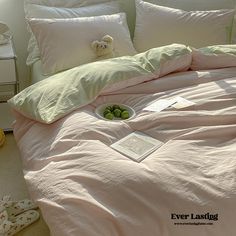 an unmade bed with pink sheets and pillows