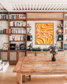 a wooden table sitting in front of a book shelf filled with books