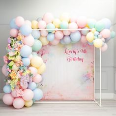 a birthday backdrop with balloons and flowers