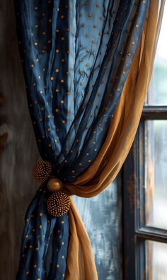 a curtain with gold dots on it hanging in front of a window