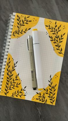 a notepad with a pen on top of it next to a spiral bound notebook