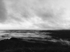 black and white photograph of fog rolling in the valley