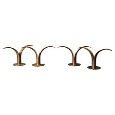 four brass candlesticks in the shape of arches