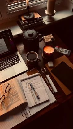 a laptop computer sitting on top of a wooden desk next to a cup of coffee