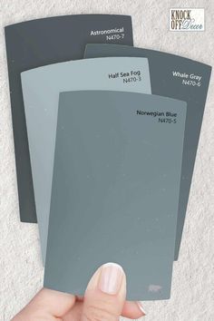 three shades of gray paint being held by a hand