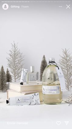 a bottle of perfume sitting on top of a table next to some books and candles