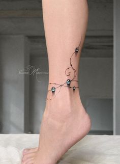 a woman's foot with a black and white tattoo on the side of her leg