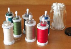 several spools of thread sitting on top of a table next to some scissors