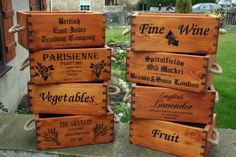 four wooden crates sitting on top of a stone slab in front of a building with grass