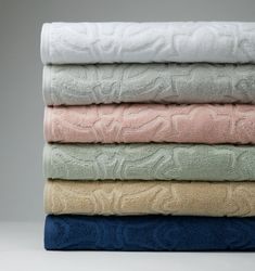 four towels stacked on top of each other in different colors and sizes, labeled with names