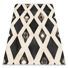 a black and white area rug with diamond shapes on the top, in front of a white background