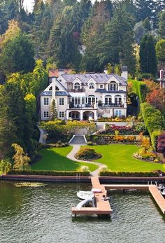 an aerial view of a house on the water with a dock in front of it