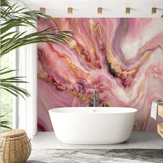 a bath tub sitting next to a plant in a bathroom under a painting on the wall