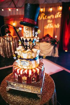 a three tiered cake is decorated with circus themed decorations