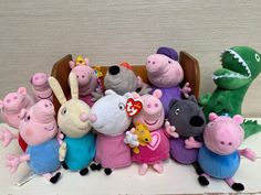 a group of peppa pig stuffed animals sitting next to each other on a table