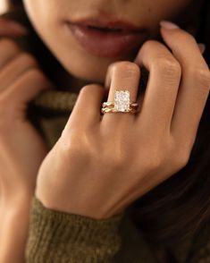 a close up of a person wearing a gold ring with a diamond in the middle