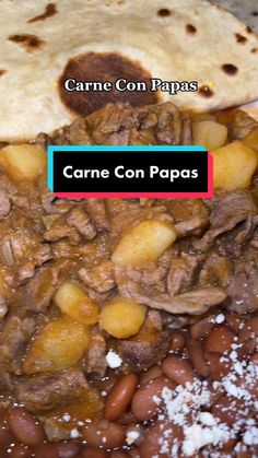 a white plate topped with meat and beans next to tortilla bread on top of a table