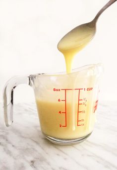 homemade sweetened condensed milk in a measuring cup