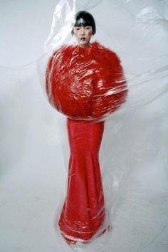 a woman in a red dress wrapped in plastic