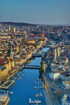 an aerial view of a city with boats in the water and buildings on both sides