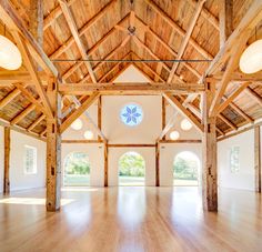 an empty room with wood floors and vaulted ceiling