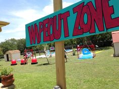 a sign that says wipeout zone in front of a play ground and playground area