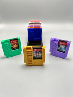 The perfect solution to organizing your switch games with a touch of nostalgia. we have the option of the base section having five or ten slots.  the color selection in the listing is for the base. make sure to add in the personalization section what colors you are wanting for the cartridges. if the personalization section is left blank, then all of the cartridges will be grey. also if you do not select enough colors, the remaining ones will be made grey.  colors available include: red blue purp Switch Game Holder, Game Holder, Office Desk Storage, Switch Games, Bleu Violet, Storage Items, Desk Storage, White Beige, Pink Yellow