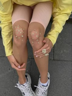 the legs of a woman with glitter on them are covered in gold and white stars