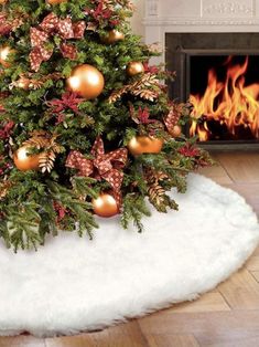 a decorated christmas tree in front of a fireplace