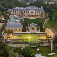 an aerial view of a mansion with a tennis court