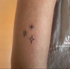 a woman's arm with three small stars on the back of her left arm