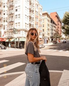 a woman standing in the middle of a cross walk