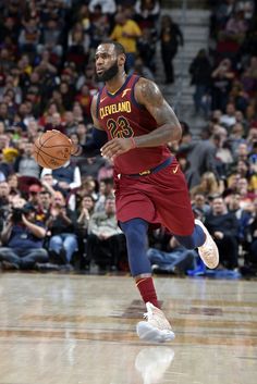 a basketball player dribbling the ball during a game in front of an audience