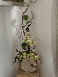 a vase filled with flowers sitting on top of a wooden block